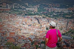 hombre con camiseta rosa mirando la ciudad de Barcelona