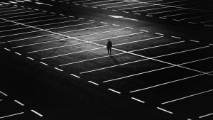 parking de noche con un hombre paseando entre las líneas del parking