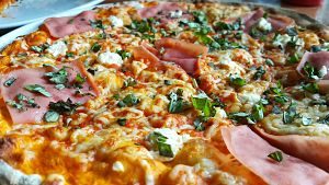 Primer plano de un pizza de jamon y queso