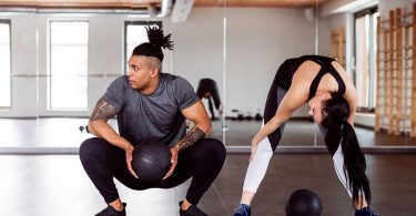 Pareja haciendo pilates en un gimnasio