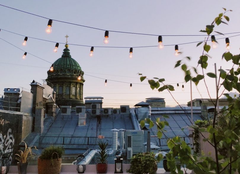 Un balcón decorado con luces en el texto y el atardecer