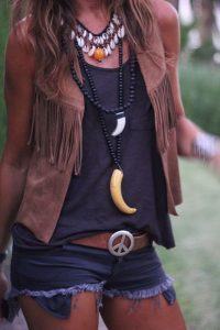 mujer con ropa hippie con colgantes de cuerno y chaleco de flecos