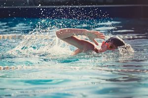 Niño nadando en una piscina descubierta