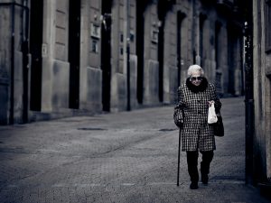 señora con bastón paseando por las calles de Barcelona