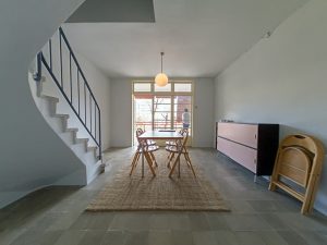 escaleras en un duplex blanco con una mesa de comedor