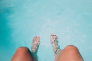 Persona se moja los pies en una piscina