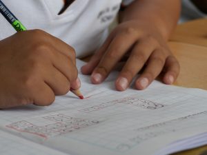 niño escribiendo en su pupitre