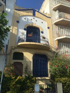 Casa amarilla con azul de dos plantas.