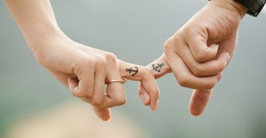mano de una mujer y hombre con el mismo tatuaje en el dedo índice