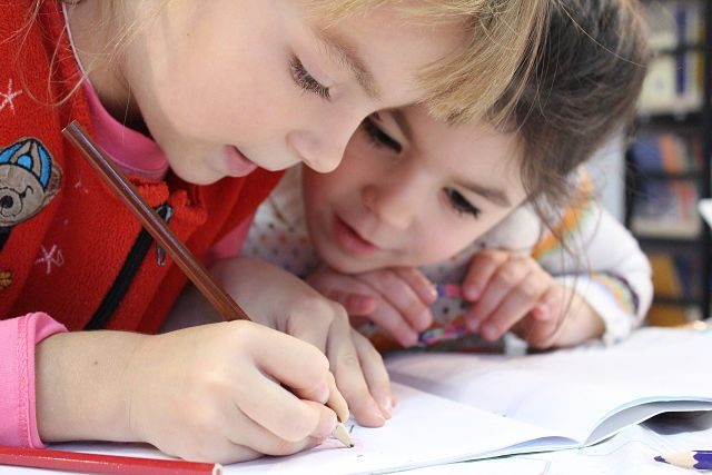 Imagen de dos niñas escribiendo en un cuaderno