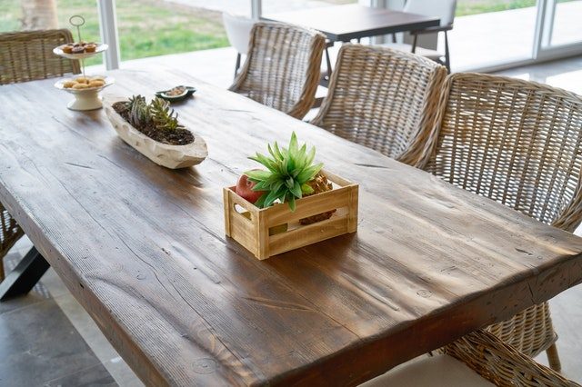 Mesa de madera con centro de mesa de flores y comida