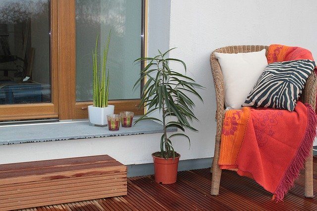 silla de mimbre en una terraza junto con plantas