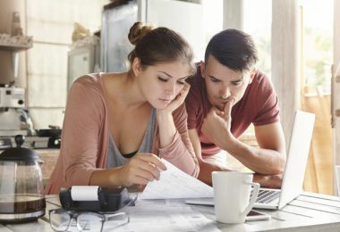 Un chico y una chica revisan un documento con atención.