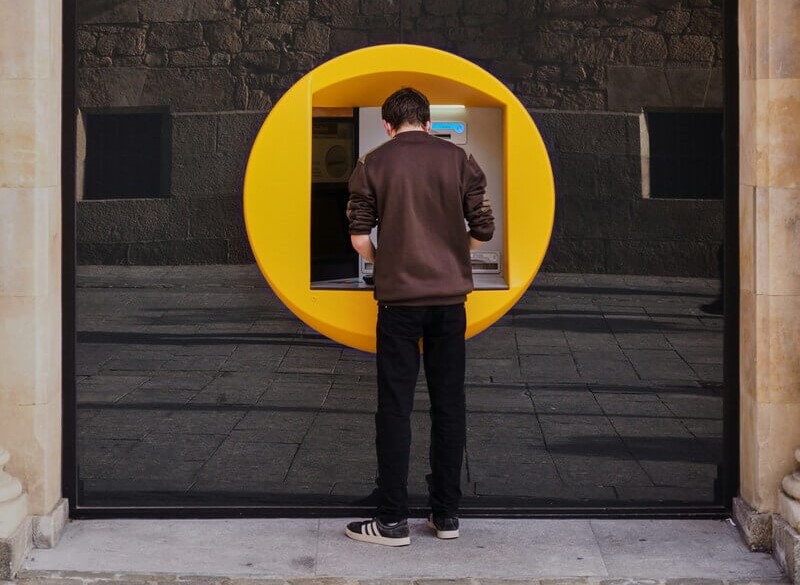 Una persona sacando dinero de su cuenta bancaria. Foto: Manuel via Unsplash