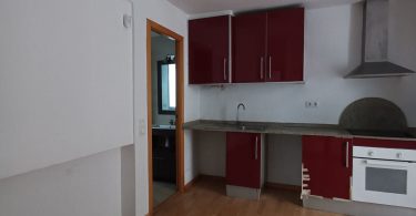 Cocina tipo abierta sin reformar, con suelos de parquet y paredes blancas.